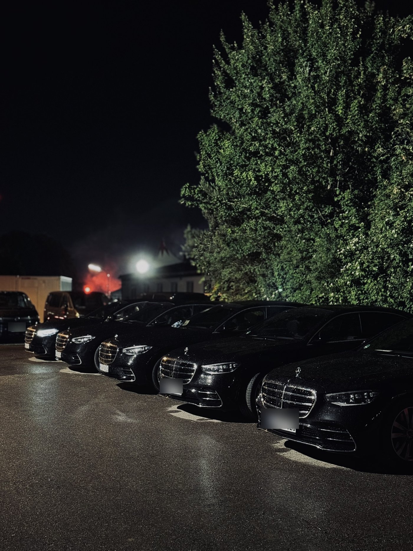 Reihe schwarzer Mercedes S-Klassen bei Nacht am Festivalgelände